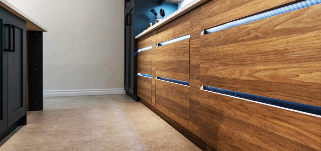 Wood grain drawers with blue lights underneath. By Sarnia Cabinets.