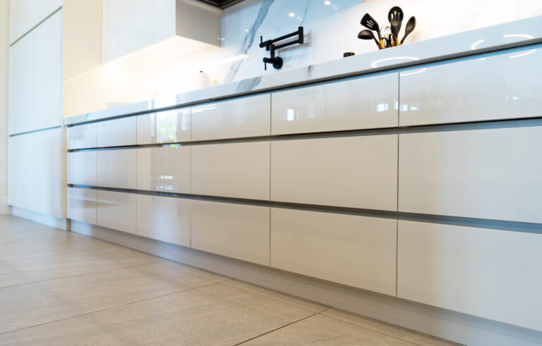 Glossy white kitchen cabinets with wood grain island in Sarnia, Ontario. Design, built and installed by Sarnia Cabinets.