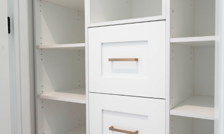 White shelves and drawers in entryway by Sarnia Cabinets.