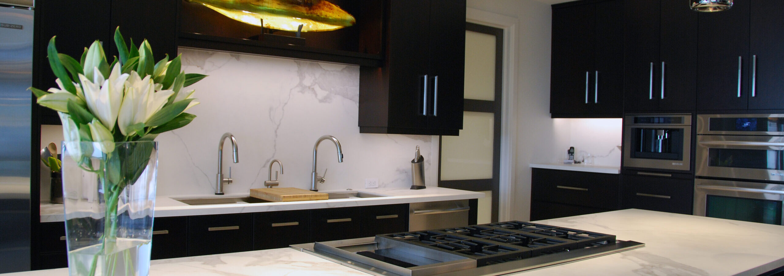 Dark brown cabinets in a Sarnia Cabinets ktichen with marble backsplash and large island.