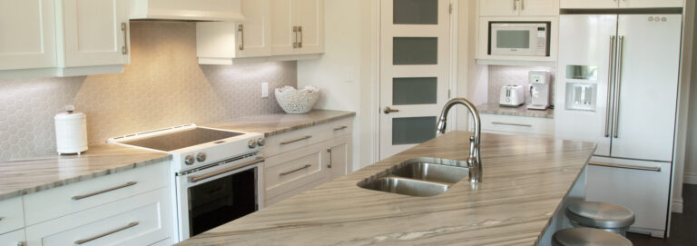 White kitchen design including island and cabinetry in Sarnia, Ontario. Brushed silver handles and faucet.