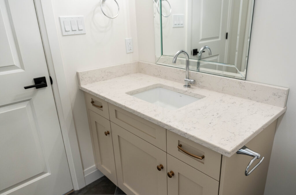 Off-white bathroom vanity with granite countertop and polished accessories.